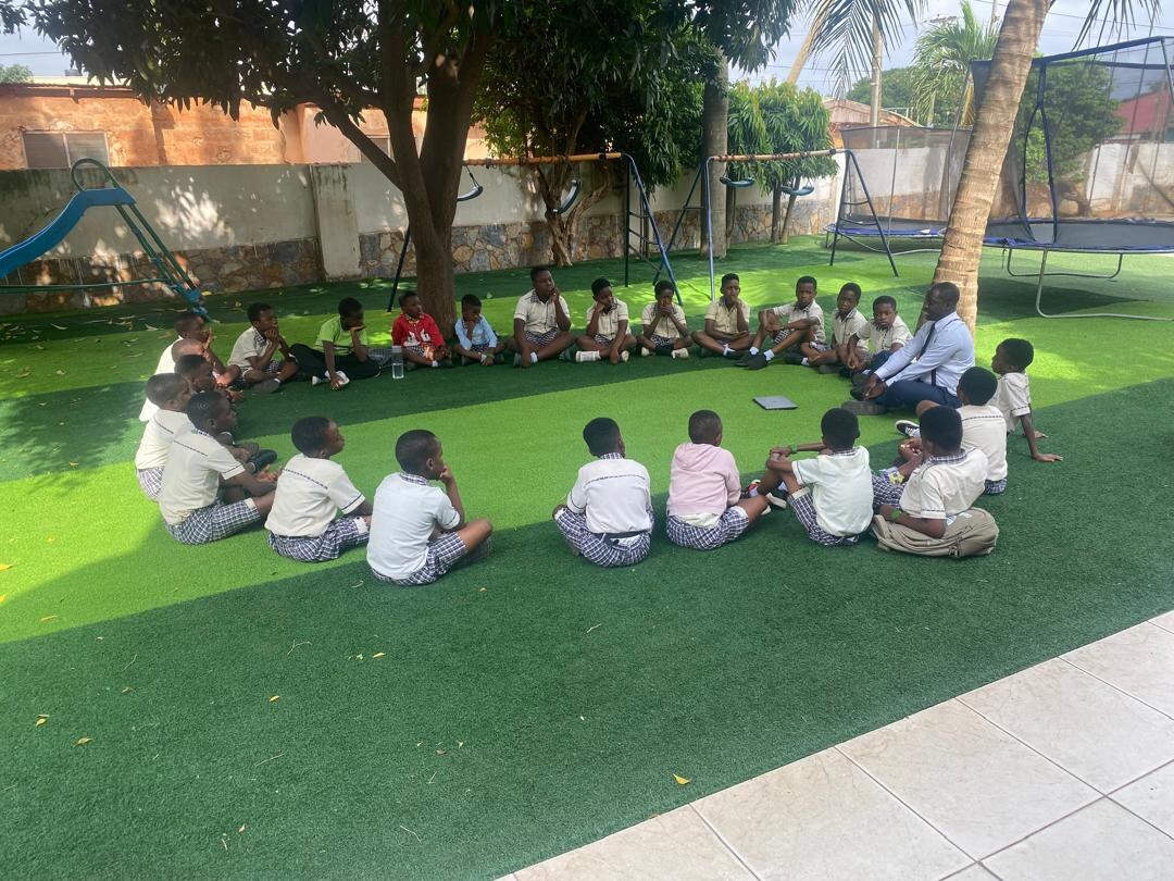 Atlantic Academy pupils learning together beneath mature shade trees